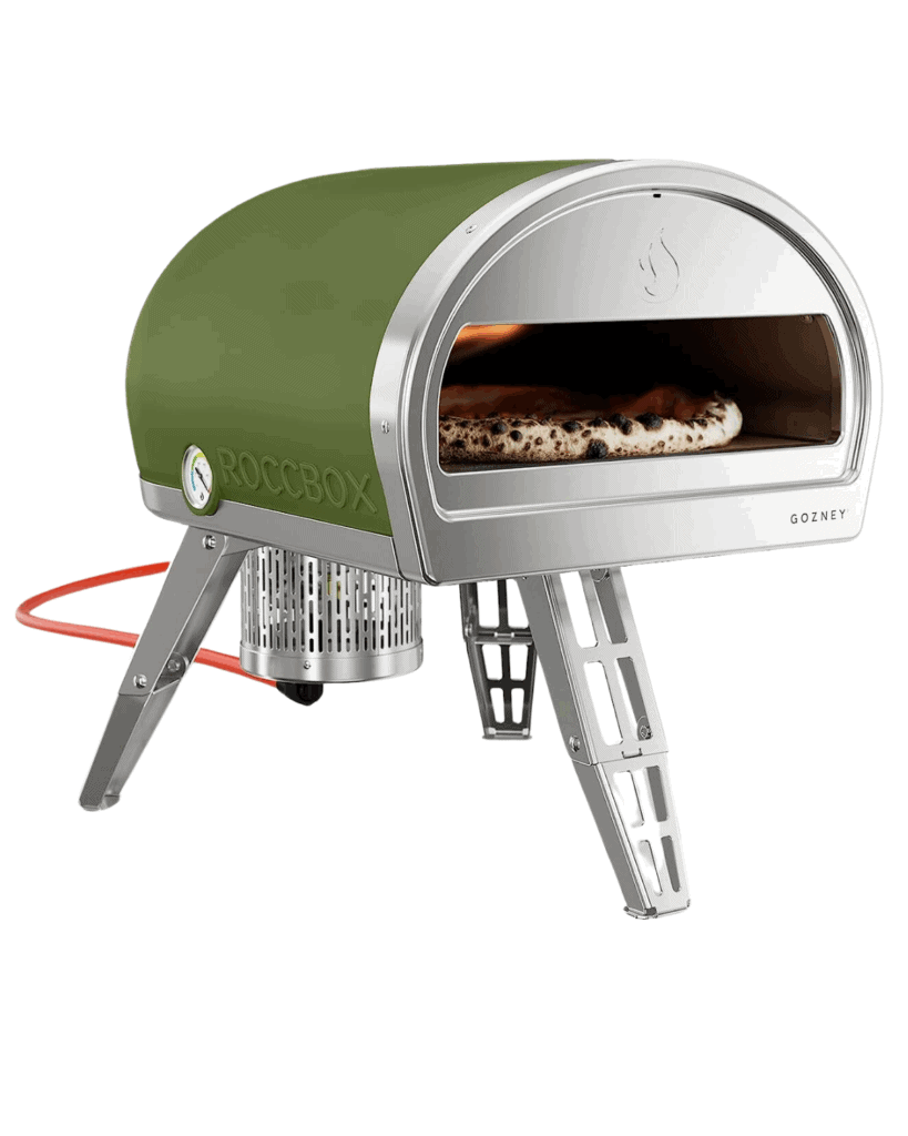 A green and silver portable outdoor pizza oven, perfect as a Father's Day Gift, with a pizza baking inside. It stands on foldable metal legs and is connected to a gas hose.