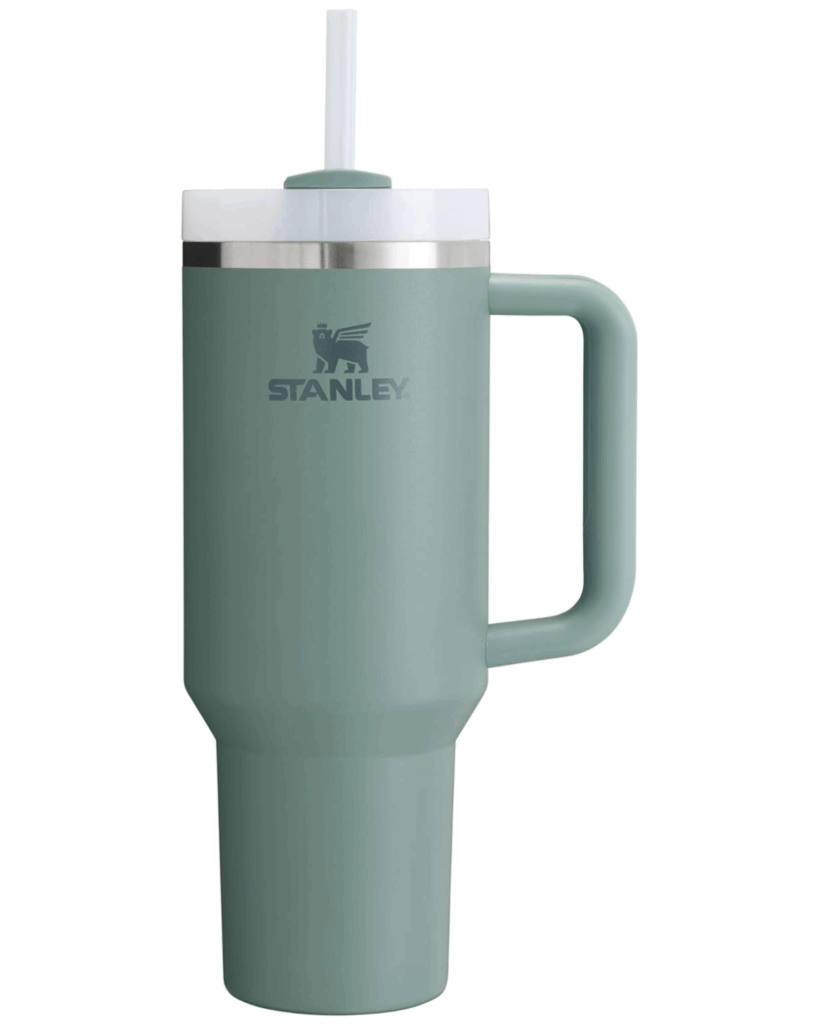A sage green Stanley tumbler with a handle, stainless steel top, clear lid, and white straw—perfectly photographed against a white background, making it an ideal pick for any Graduation Gift Guide.