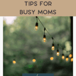 A string of outdoor lights hangs against a blurred green background, with text overlay: "Outdoor Decor Tips for Busy Moms.