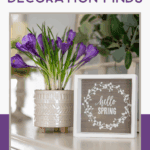 A potted purple flower and a wooden sign that reads "hello SPRING" sit on a table, with green foliage in the background. Text above reads "Fresh Spring Home Decoration Finds.