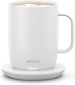 A white Ember smart mug sits on its matching charging coaster, filled with a hot beverage. The simple, modern design with the Ember logo makes it a standout pick for Thursday Deals.
