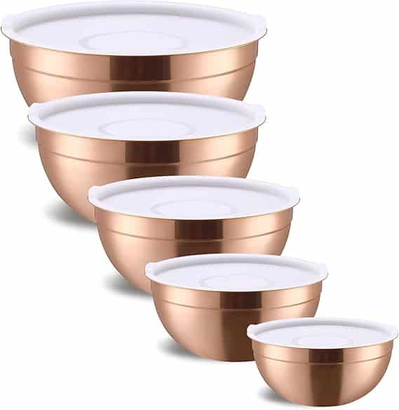 A set of five metallic mixing bowls with white lids, arranged in descending size order from back to front, each bowl features a reflective copper finish—perfect for your kitchen and available now in our Thursday Deals.