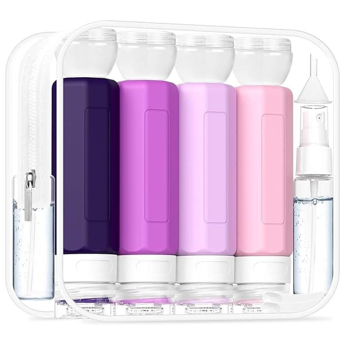 A clear travel toiletry bag featuring four silicone squeeze bottles in purple and pink shades, plus a small clear spray bottle, all neatly arranged—perfect for your next trip. Don’t miss our exclusive Tuesday Deals on this must-have set!.