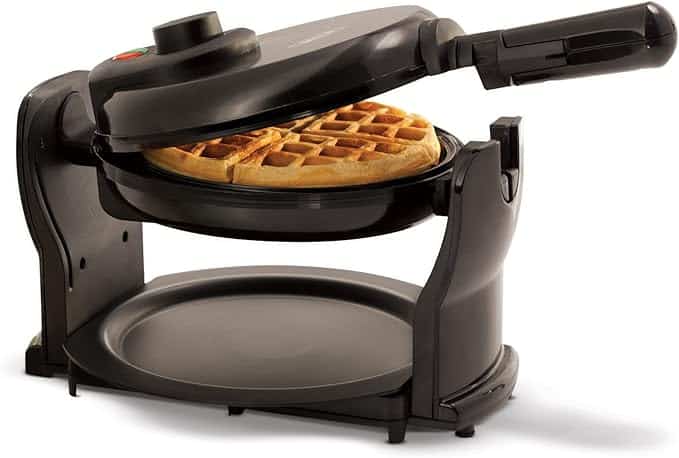 A black rotating waffle maker with its lid open, showing a freshly cooked golden-brown waffle inside. A round drip tray sits underneath to catch any spills—perfect for grabbing during Friday Deals.