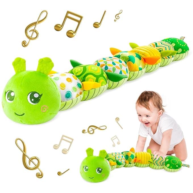 A smiling baby crawls toward a colorful, plush caterpillar toy with a green head. Floating music notes surround them, hinting at its musical features—perfect for playtime fun and available now as part of exclusive Tuesday Deals.