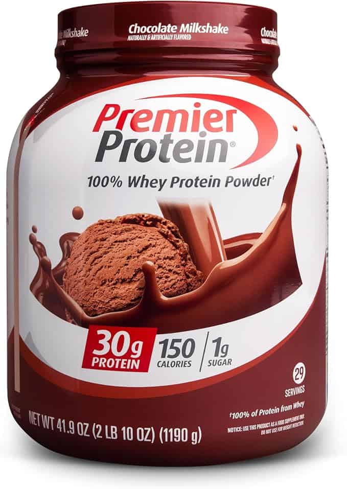 A container of Premier Protein 100% Whey Protein Powder in chocolate milkshake flavor, featuring a scoop of powder and a chocolate splash. The label highlights 30g protein, 150 calories, and 1g sugar per serving—perfect for Monday Deals.