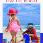 Toddler in a sunhat walking near towels and toys, highlighting practical beach day essentials.
