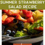 A fresh summer salad with strawberries, blueberries, and leafy greens is shown in a close-up. Overlaid text reads, "Our Favorite Summer Strawberry Salad Recipe. Read more. thebargainsisters.com.
