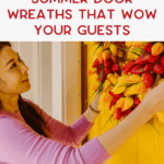 A woman in a pink sweater hangs a vibrant wreath made of red and yellow tulips on a bright yellow door. Text above her reads, "Summer door wreaths that wow your guests.
