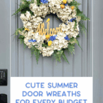 A gray front door displays a floral summer wreath with white, blue, and yellow flowers, green ferns, and a "Welcome" sign. Text below reads: "Cute Summer Door Wreaths for Every Budget.
