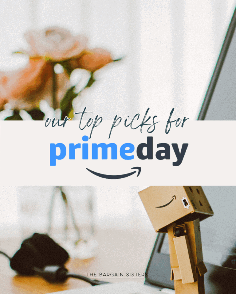 A small cardboard robot figure stands by a laptop and pink roses. Overlaid text reads, "Our top picks for Amazon Prime Day," with "prime" in blue and an Amazon smile logo. At the bottom: "The Bargain Sisters.