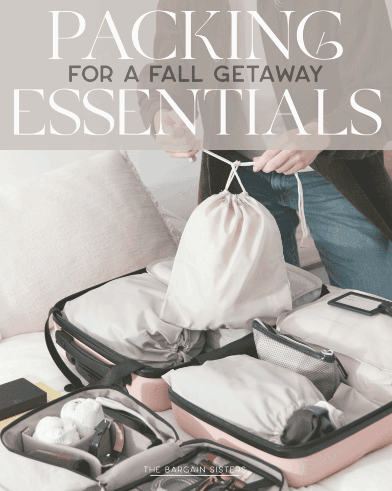 A person packing an open suitcase on a bed with organized travel essentials and clothing, holding a drawstring bag. The image text reads: "Packing for a Fall Getaway: Things to Pack Essentials.
