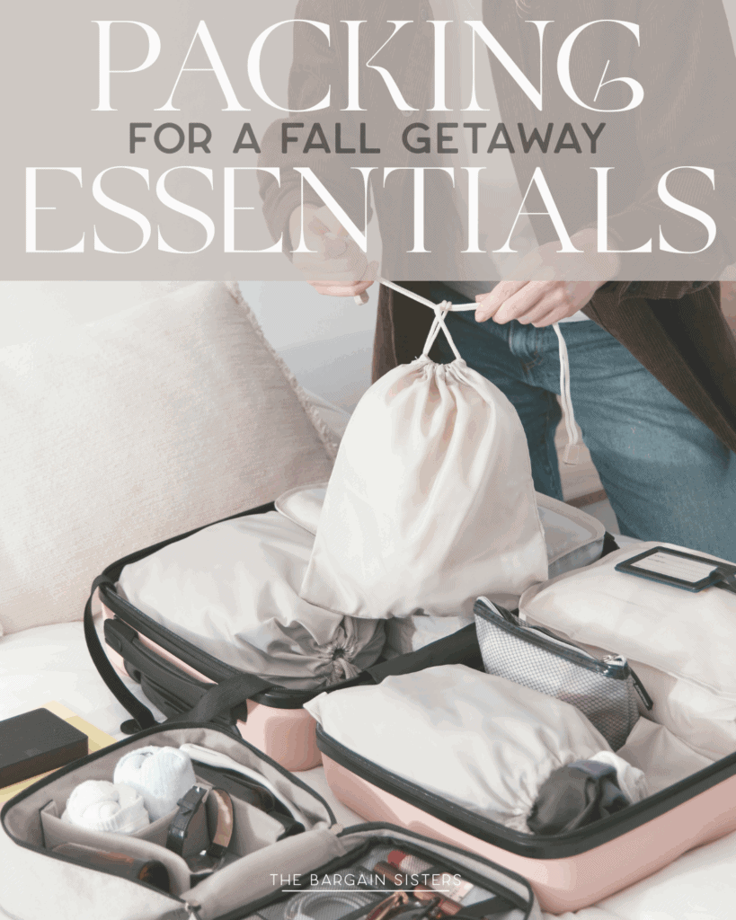 A person packing an open suitcase on a bed with organized travel essentials and clothing, holding a drawstring bag. The image text reads: "Packing for a Fall Getaway: Things to Pack Essentials.