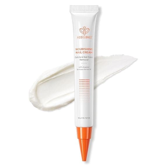 A tube of Modelones Nourishing Nail Cream with an orange cap is displayed on a white background, next to a smear of white cream. Perfect for cuticle and nail polish removal—don’t miss out on exclusive Tuesday Deals!.