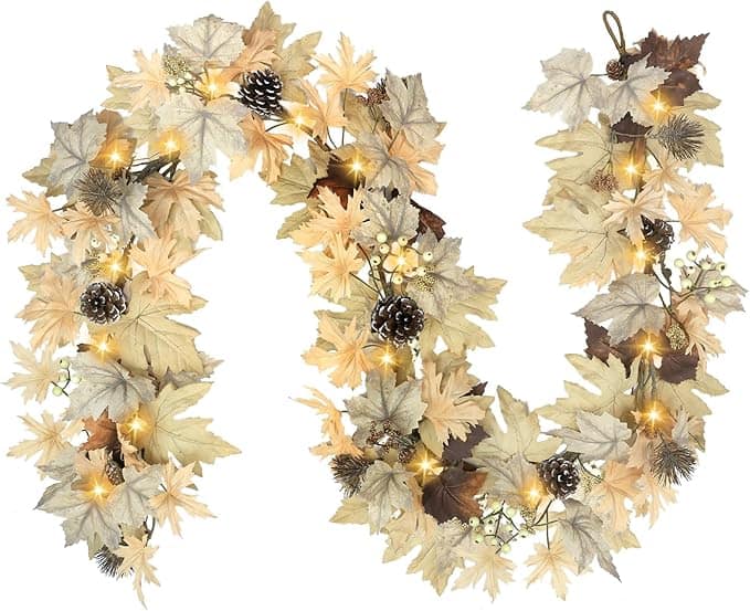 A decorative autumn garland with beige, gold, and brown leaves, pine cones, small berries, and warm white string lights—perfect for cozy décor and even better with exclusive Monday Deals.
