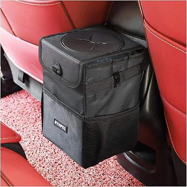A black car trash can with a lid is attached to the back of a red car seat, hanging neatly and featuring mesh side pockets, with red carpet below—perfect for organizing your ride. Don't miss out on exclusive Tuesday Deals!.