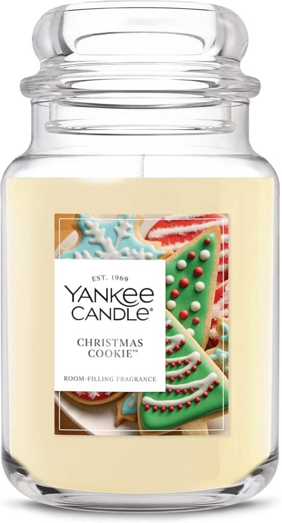 A large glass jar candle labeled "Yankee Candle Christmas Cookie" with a picture of decorated holiday cookies on the front. The creamy off-white wax and festive scent make it perfect for cozy nights—and even better during Friday Deals.