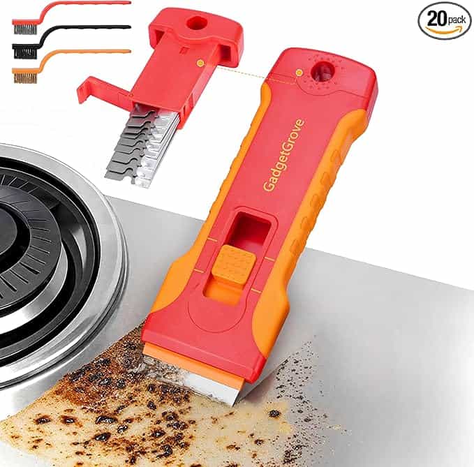 A red and orange scraper tool labeled "GadgetGroove" tackles burnt residue from a stovetop. A pack of extra blades and two small cleaning brushes are shown behind. Text reads "20 pack." Perfect for Tuesday Deals shopping!.