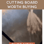 A stream of water is sprayed onto a shiny titanium cutting board. Text reads: “Durable titanium cutting board worth buying. Shop now. thebargainsisters.com.”.