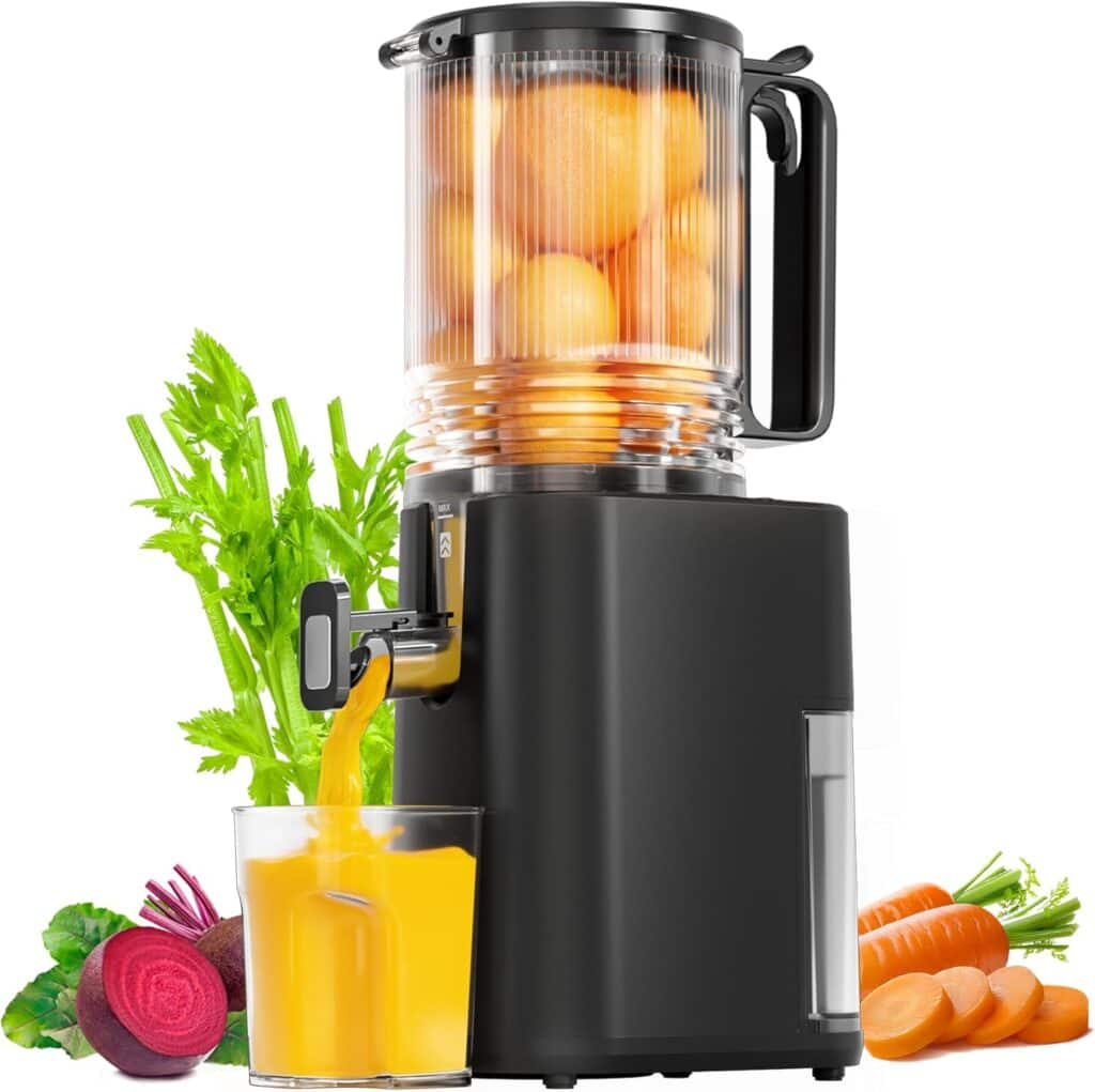 A black juicer with a transparent container full of oranges pours fresh juice into a glass. Fresh carrots, celery, and a beet are placed beside the juicer—perfect for healthy drinks and unbeatable Tuesday Deals.