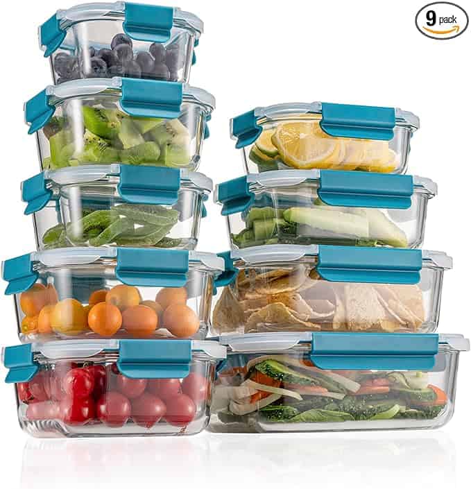 Nine glass food storage containers with blue locking lids are stacked, each filled with fresh fruits, veggies, or cooked foods—perfect for meal prep. Don't miss these Monday Deals for organized, fresh storage all week long.
