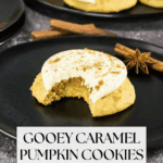 A soft pumpkin cookie with caramel frosting and a bite taken out sits on a black plate, garnished with cinnamon and star anise. Text reads: "Gooey Caramel Pumpkin Cookies.
