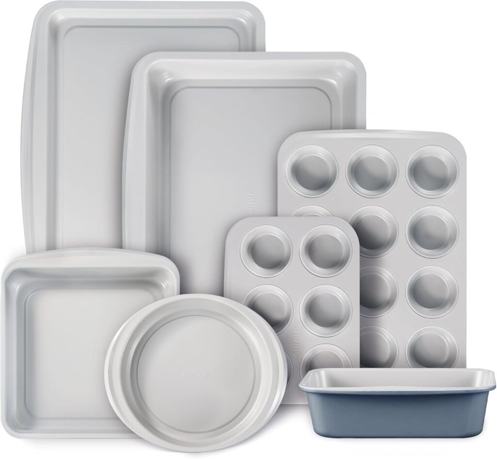 A set of seven silver baking pans in various shapes and sizes, including muffin pans, cake pans, a loaf pan, round pan, and rectangular trays, arranged overlapping on a white background.
