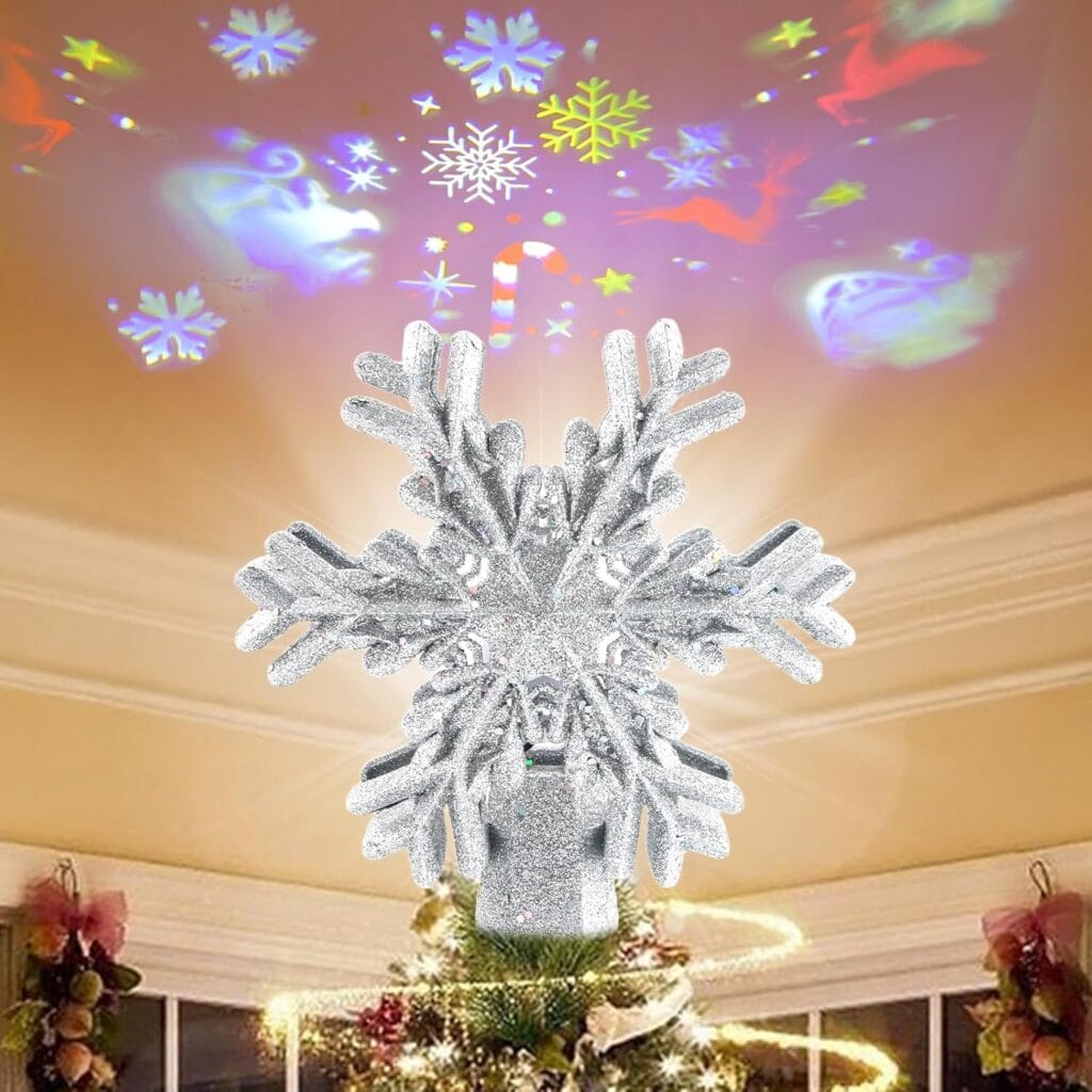 A glittery silver snowflake tree topper projects colorful Christmas-themed shapes onto the ceiling above a decorated Christmas tree—perfect for adding magic to your living room and enjoying big savings with Friday Deals.
