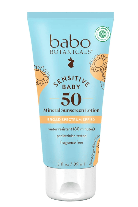 A tube of Babo Botanicals Sensitive Baby Sunscreen SPF 50 features a blue and yellow design with sunflowers. This mineral sunscreen lotion is broad spectrum, water resistant, pediatrician tested, and fragrance free.