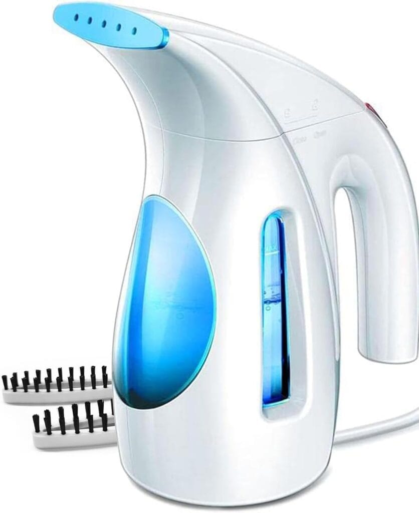 A handheld white and blue garment steamer with a curved spout, a transparent water reservoir, and two removable brush attachments placed beside it. The device is plugged in with a visible power cord.