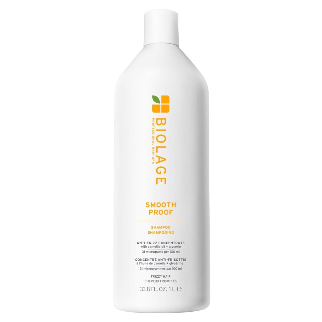 A white bottle of Biolage Smooth Proof Shampoo with a yellow and green logo, featuring text about anti-frizz concentrate for frizzy hair. This Premium Beauty product comes in a 33.8 fl oz (1 L) size.