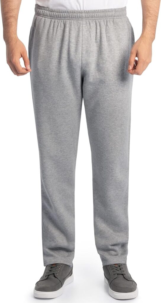 A person wearing light gray sweatpants, a white shirt, and gray sneakers stands facing forward with arms relaxed at their sides. The photo shows the person from the shoulders down.