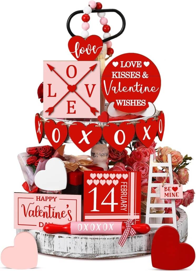 A two-tiered tray decorated with red, pink, and white Valentine’s Day signs, hearts, roses, and beads. Messages include "LOVE," "XOXO," "Happy Valentine’s Day," and "14 February.