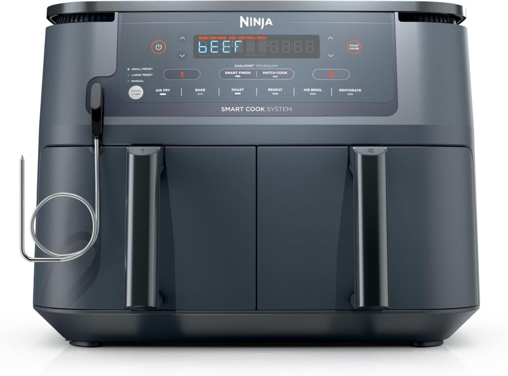 A black Ninja Smart Cook System kitchen appliance with digital display, control buttons, two pull-out compartments, and a metal probe attached to the side.