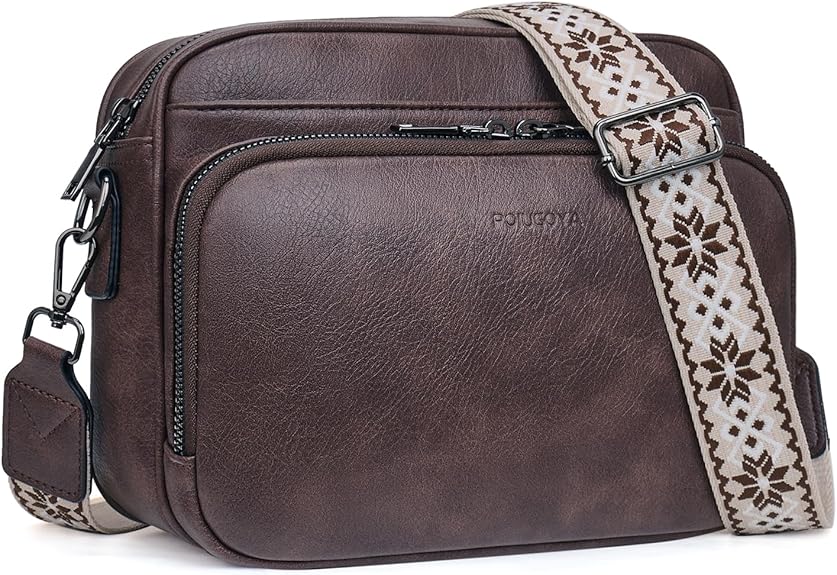 A dark brown leather crossbody bag with a large front pocket and a wide, adjustable strap featuring a beige and brown geometric pattern. The bag has black metal hardware and a simple, modern design.