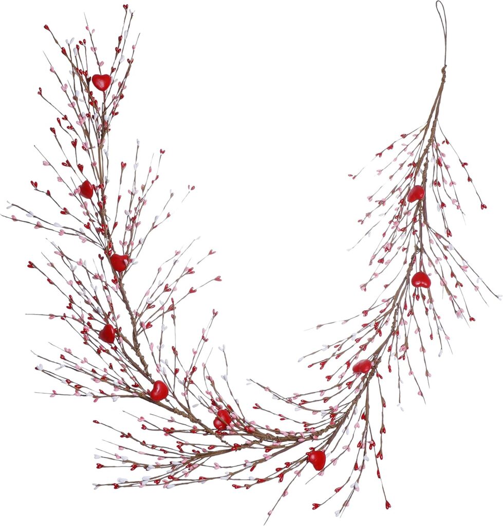 A decorative garland made of brown branches with small red heart-shaped ornaments and white accents, arranged in a curved shape with a loop at one end for hanging.