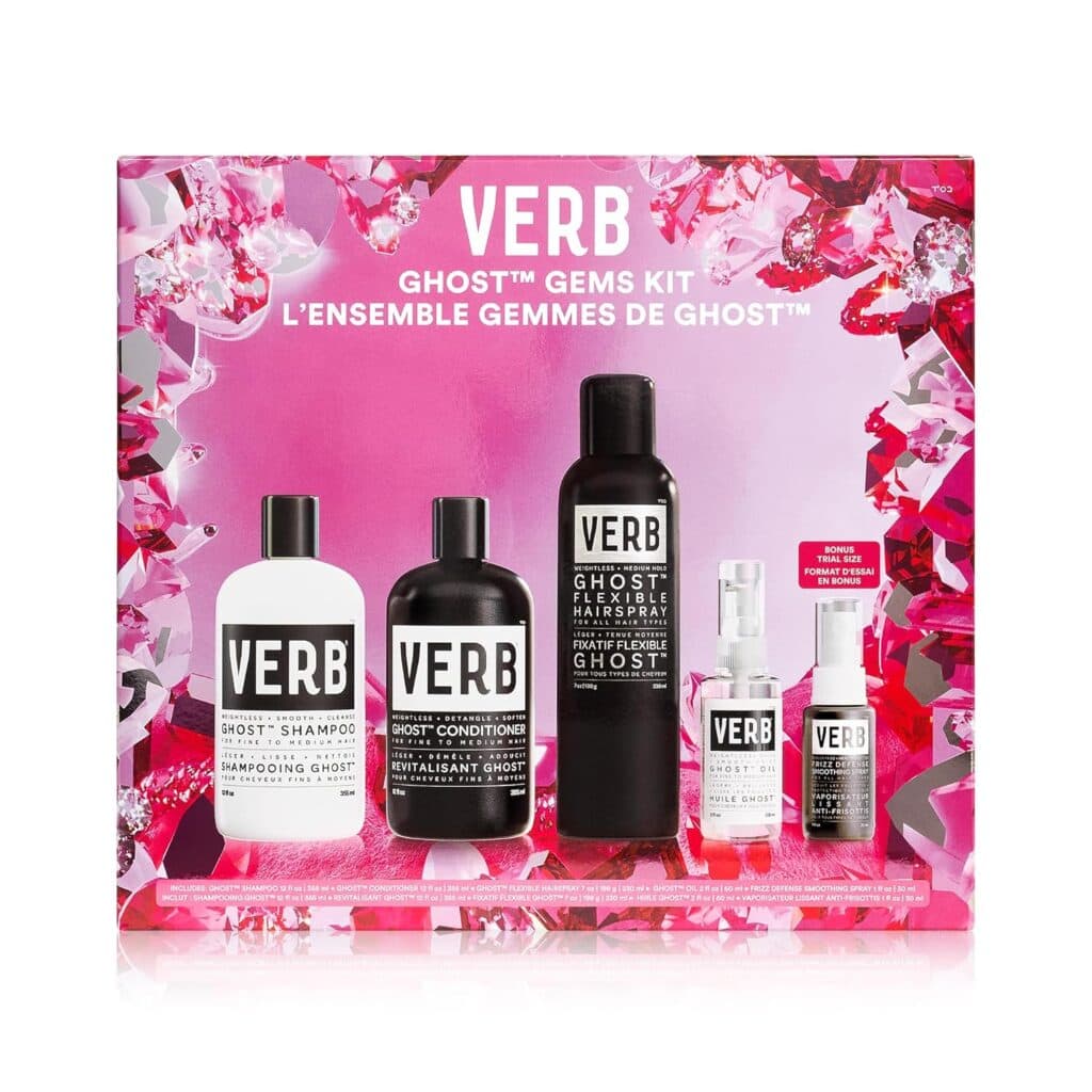 A pink and white Verb Ghost Gems Kit box with five Verb hair care products displayed in front: shampoo, conditioner, hairspray, smoothing balm, and oil, surrounded by pink, red, and clear crystal-like graphics.