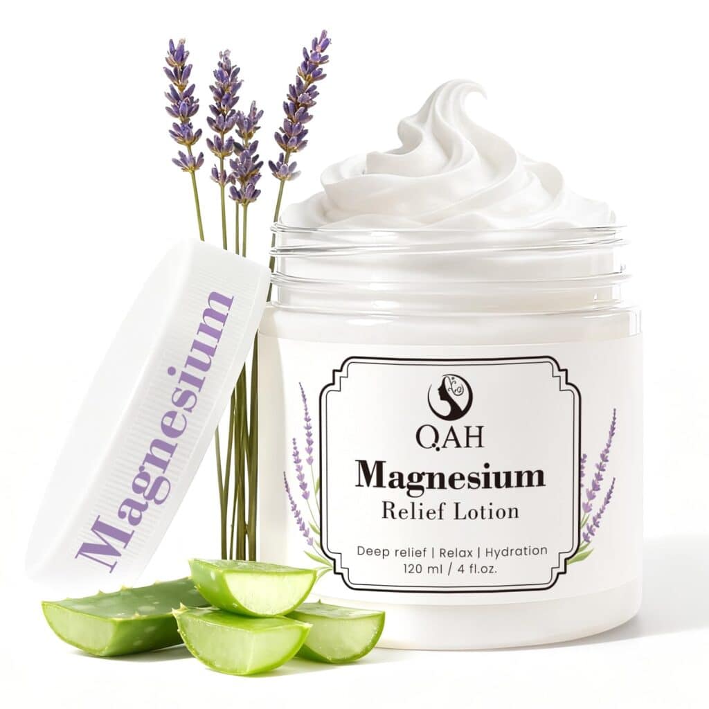 A jar of QAH Magnesium Relief Lotion with the lid off, showing creamy lotion inside. Lavender flowers and aloe vera leaves are beside the jar, highlighting natural ingredients. The label mentions deep relief, relaxation, and hydration.