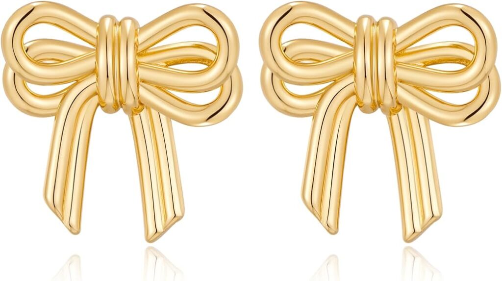 A pair of shiny gold earrings shaped like bows with loops and ribbon tails, displayed side by side on a white background.