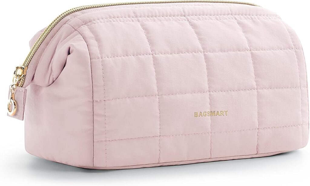 A light pink quilted cosmetic bag with a gold zipper and the word "BAGSMART" printed in gold on the front.