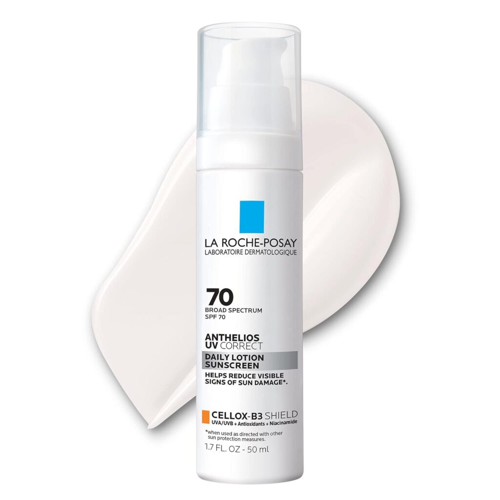 A bottle of La Roche-Posay Anthelios UV Correct sunscreen SPF 70 stands in front of a smear of white lotion on a white background. This premium beauty product is 1.7 fl oz (50 mL) and displays detailed labeling.