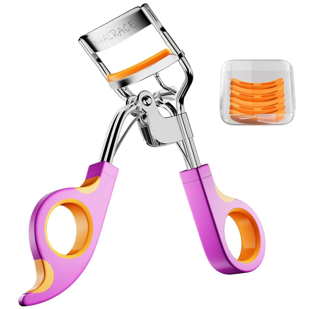 A metal Eye Lash Curler with pink and orange handles, shown with a small clear case containing several orange Replacement Pads. Now available at 50% off!.