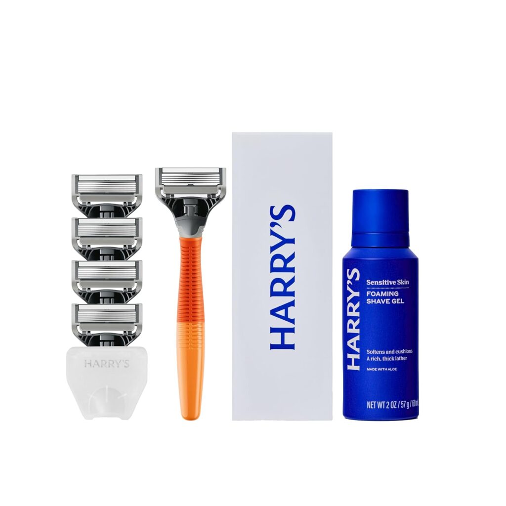 A shaving kit with an orange-handled razor, four replacement blades, a white blade cover, a white box labeled "HARRY'S," and a blue bottle of shave gel for sensitive skin.