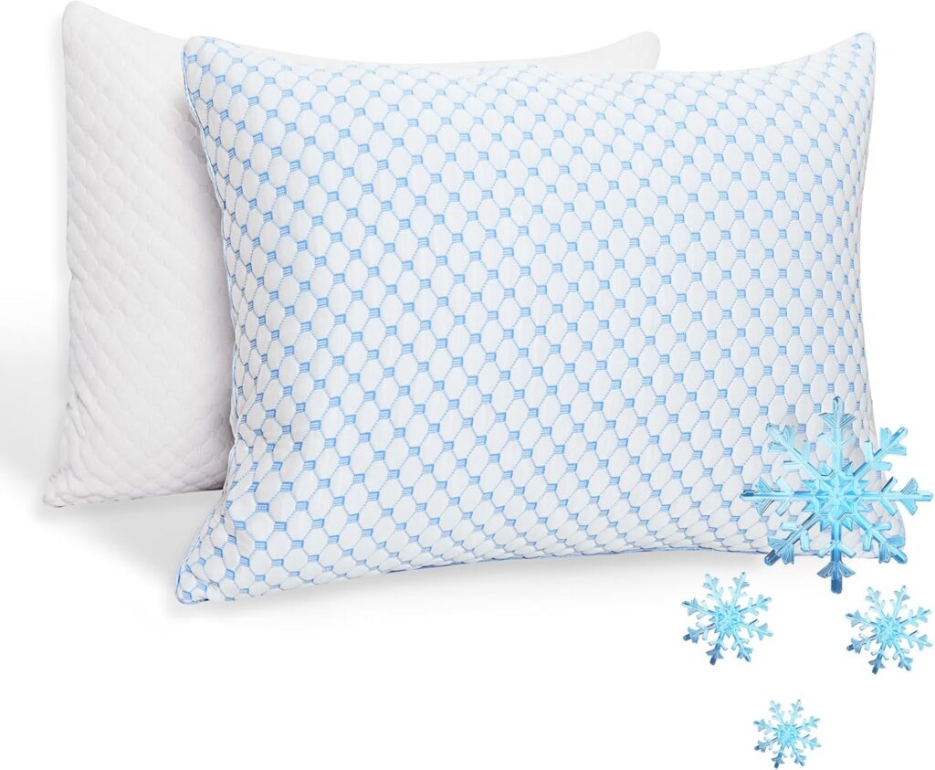 Two pillows are shown, one with a white quilted cover and one with a blue and white hexagon pattern. Several blue snowflake graphics are placed in the foreground, suggesting a cooling feature.