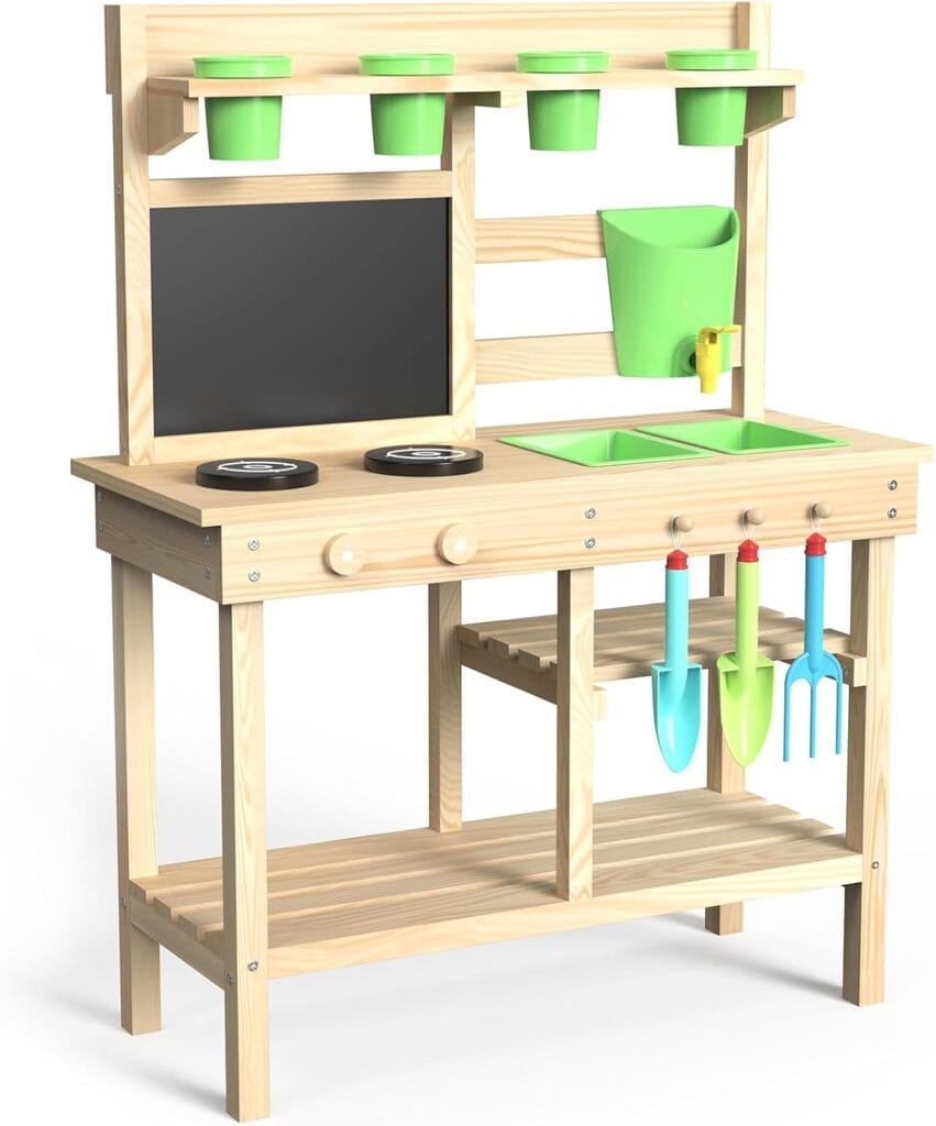 A wooden play kitchen and gardening station with green pots, a chalkboard, two green sinks, two knobs, two black stovetop circles, and hanging toy tools including a blue shovel, blue trowel, and red fork.