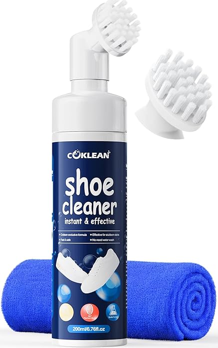 A bottle of Coklean shoe cleaner with a brush head attached, an extra brush head, and a blue cleaning cloth, designed for instant and effective shoe cleaning.