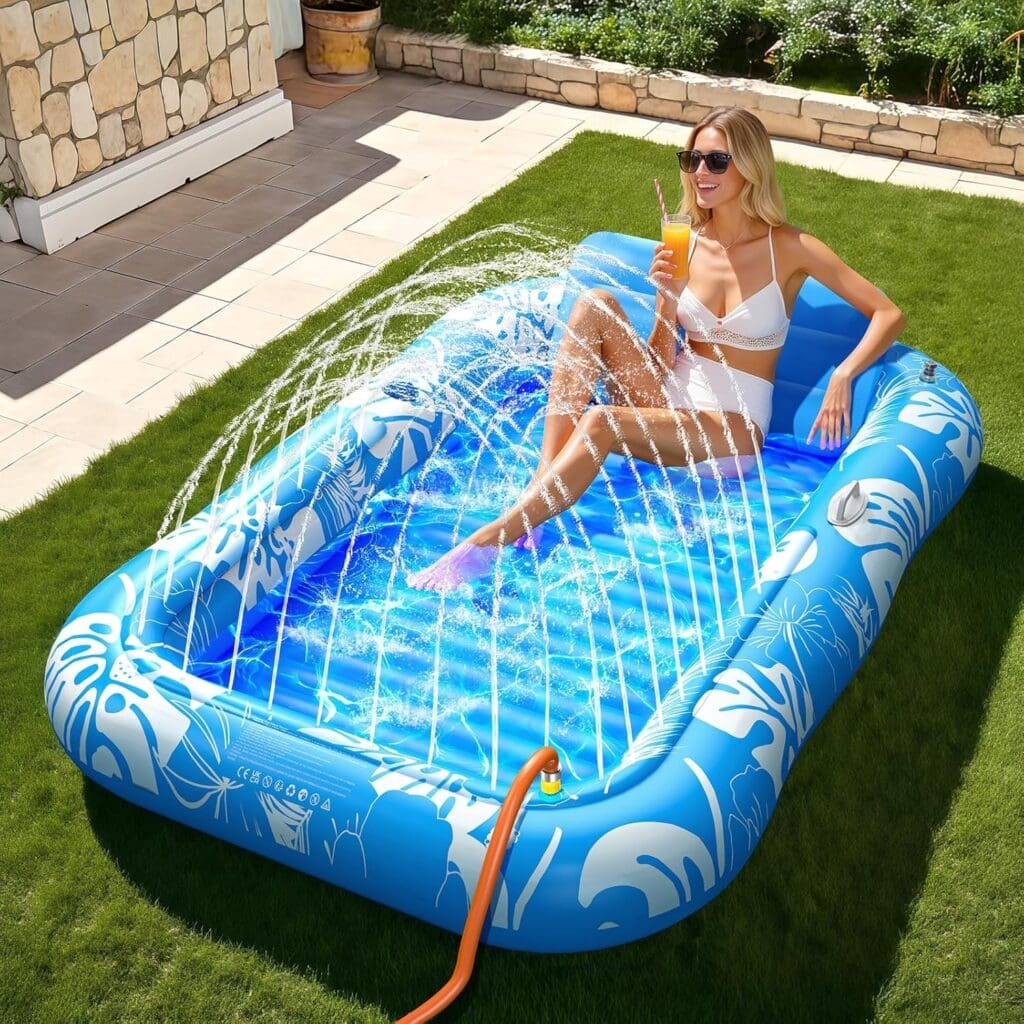 A woman in a white swimsuit relaxes in a blue inflatable pool with water sprays, holding a drink and smiling, surrounded by green grass in a sunny backyard.