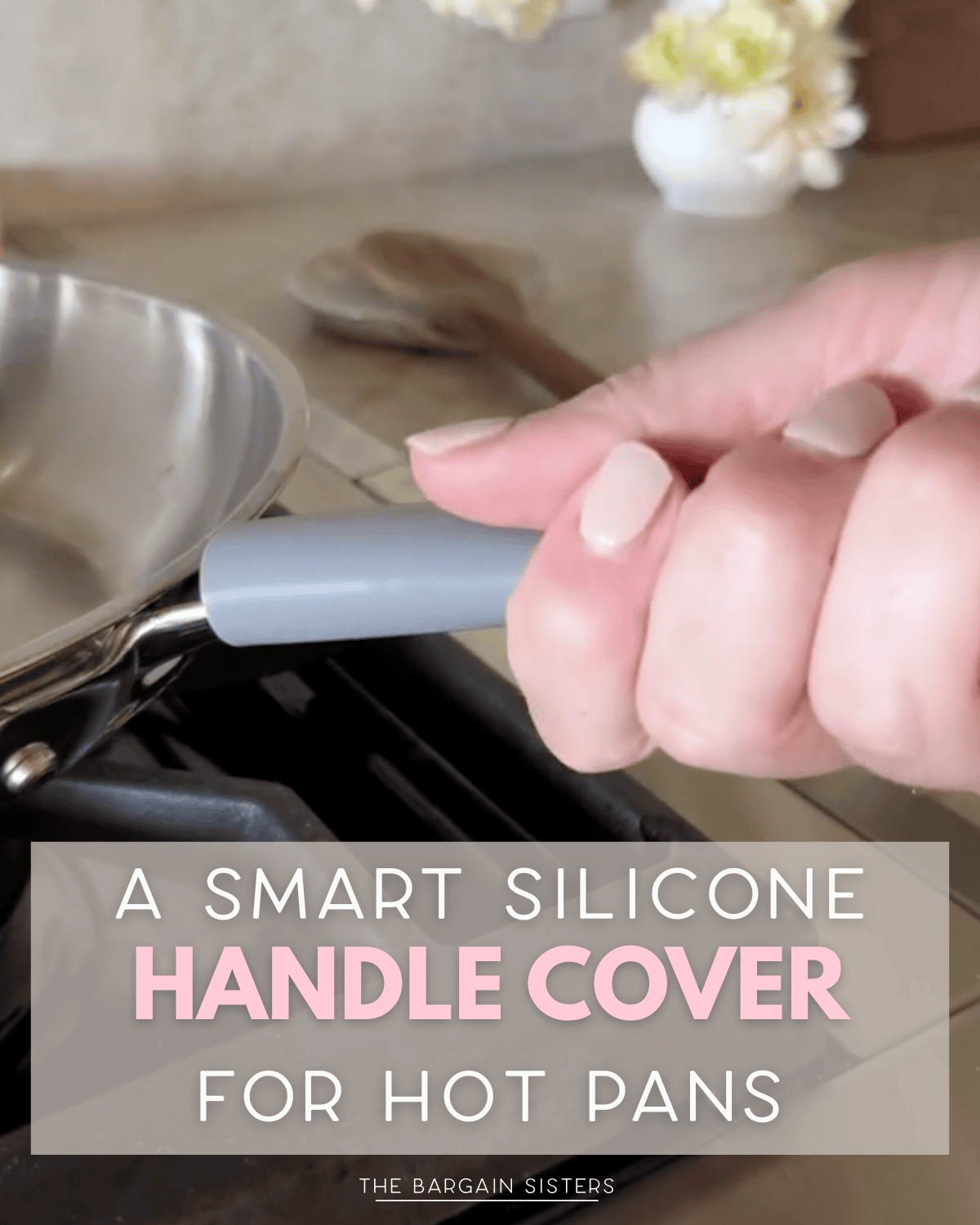 A hand grips a pan with a gray silicone handle cover over a stove. Text reads: "A smart silicone handle cover for hot pans—perfect for moms who love practical kitchen tools." A vase of flowers and cake accessories are in the background.