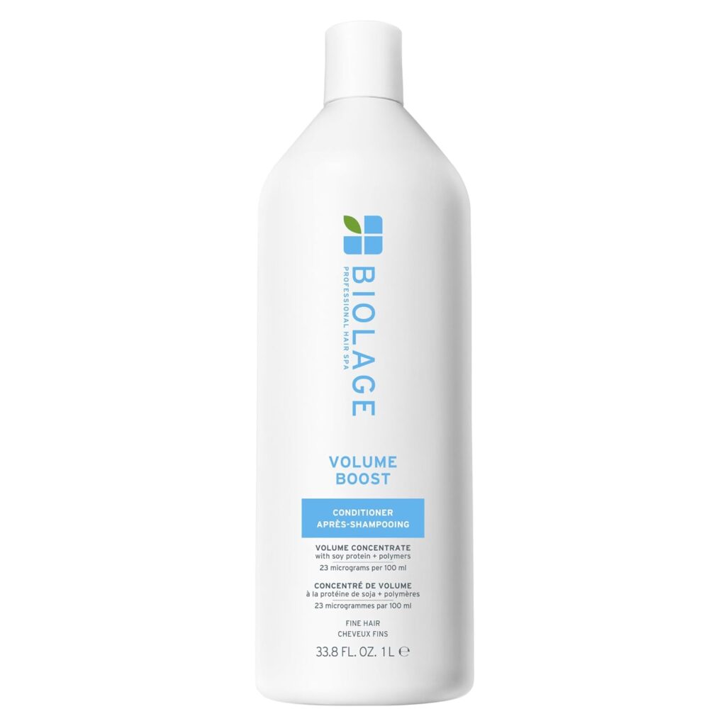 A white 1-liter bottle of Biolage Volume Boost Conditioner with blue and green accents, featuring text that highlights premium beauty volume concentrate for fine hair and a convenient pump dispenser at the top.