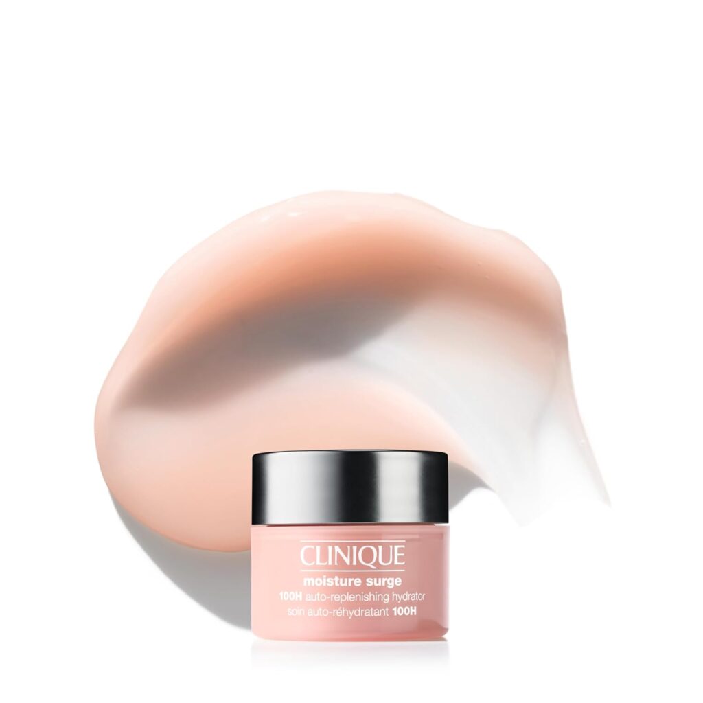 A jar of Clinique Moisture Surge 100H Auto-Replenishing Hydrator is placed in front of a smear of creamy, pink moisturizer on a white background.